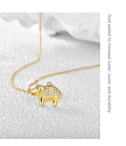 Dettaglio macro di una collana con ciondolo a elefante placcato oro con cristalli bianchi