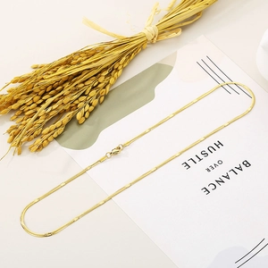 Dettaglio di una collana a catena serpente dorata da 2,2 mm con maglie piatte quadrate