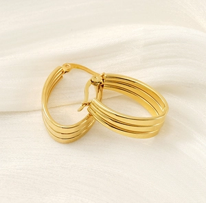 Détail de boucles d'oreilles créoles triple couche plaquées or 18 carats sur soie