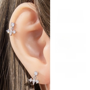 Detail of silver geometric zircon stud earrings showing cluster design on a model ear