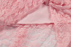 Macro detail of pink floral lace fabric with professional stitching and smooth lining