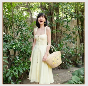 Detail of a large straw tote bag with lemon embroidery and woven texture for summer beach