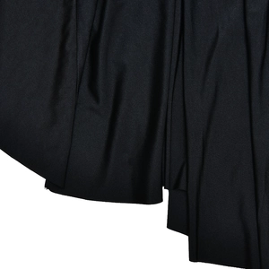 Close-up of black ruched dress fabric showing detailed texture and elegant pleats