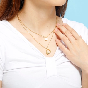 Vue détaillée du collier double couche doré avec pendentif cœur Mama et gravure d'étoile