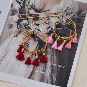 Detail of vintage gold hairpins and bracelets featuring elegant red and pink silk tassels
