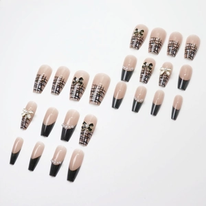 Faux ongles nude rose français avec motifs quadrillés noirs et nœuds 3D en perles