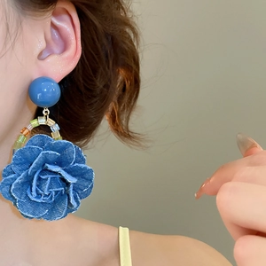 Gros plan de boucles d'oreilles rose en denim avec perles colorées sur un mannequin