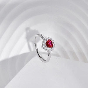 Detailed macro view of heart-shaped ruby ring with halo diamond setting in silver