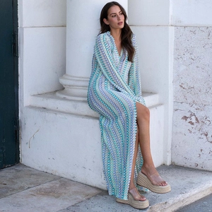 Detail of color-block crochet knit dress showing geometric pattern and high side slit
