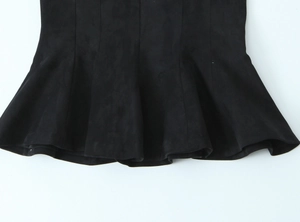 Détail du tissu en suédine noire avec un ourlet à volants élégant et texture douce