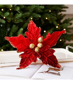 Vue macro d'un poinsettia en velours rouge avec bordures dorées pour décoration de Noël
