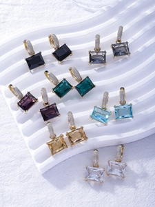 Macro detail of colorful rectangular zircon earrings with gold micro-paved crystal clasps