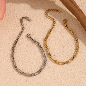 Detail of minimalist paperclip chain bracelets in silver and gold over stainless steel