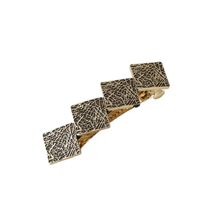 Vintage golden irregular round hair clip with engraved metal texture on white background