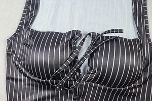 Detail of striped swimwear showing criss-cross lace-up design and knit texture