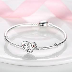 Close-up of a silver heart charm with family engraving and red enamel on snake chain