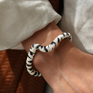 Close-up of zebra print leather bracelet with irregular geometric curved design on wrist