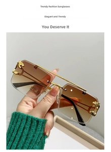 Close-up of golden cheetah head metal detail on rimless gradient brown sunglasses