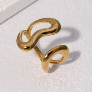 Polished 18k gold wave geometric ring on a textured stone pedestal, minimalist style