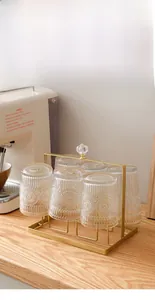 Dettaglio di un porta bicchieri dorato di lusso con sei bicchieri vintage su tavola di legno
