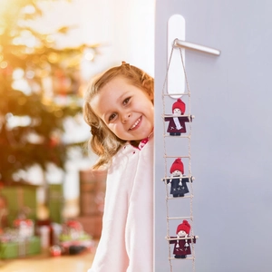 Three wool felt Santa dolls on a rope ladder hanging on a door for Christmas decor