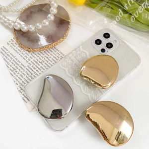 Macro view of metallic gold and silver bean-shaped mirror phone grips on a phone case