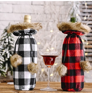 Close-up of red and black plaid Christmas wine bottle covers with plush faux fur trim