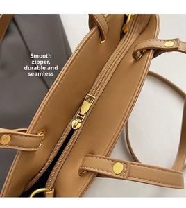 Detailed close-up of smooth golden zipper closure on woven straw bucket bag with PU trim