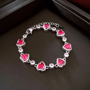 Macro view of silver heart bracelet with pink zircon stones and adjustable clasp