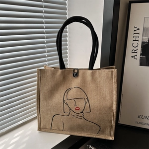 Ethnic style beige jute tote bag with minimalist line art portrait and black rope handles