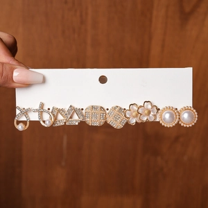 Close-up of elegant gold earrings set featuring faux pearls and sparkling rhinestones