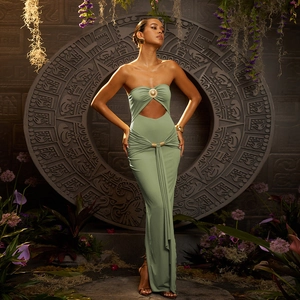Détail de la robe longue vert sauge avec découpe à la taille et boucle en métal doré