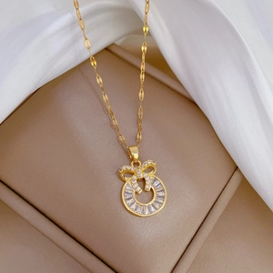 Luxurious gold titanium necklace with a micro-paved bow pendant on a silk background