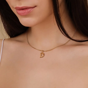 Primer plano del collar con colgante de letra D dorada y cadena cubana de 2 mm