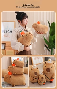 Detail of plush capybara toys in various sizes with orange and bird accessories