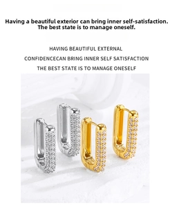 Close-up of U-shaped stainless steel huggie earrings with pave cubic zirconia stones