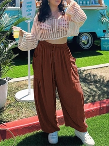 Detail of high waisted wide leg cotton linen pants with drawstring in rust red