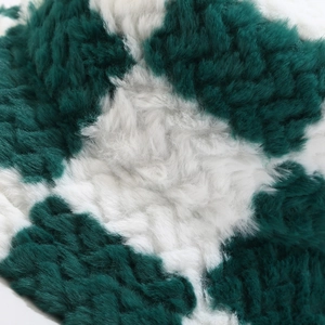 Close-up of thick plush faux fur fabric with green and white checkerboard pattern