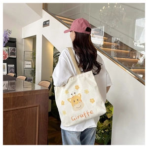 Detail of white canvas tote bag featuring a cute giraffe print and words Giraffe