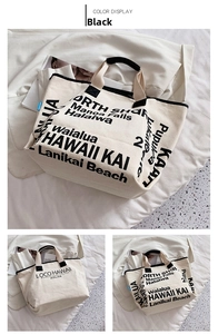 Nahaufnahme der cremefarbenen Canvas-Tasche mit schwarzem Hawaii-Druck und Tragegriffen