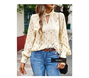 Detail of elegant white long sleeve shirt featuring gold teardrop print and V-neckline