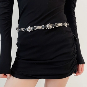Detail of black leather waist chain with silver sunburst metal disks and tribal buckles