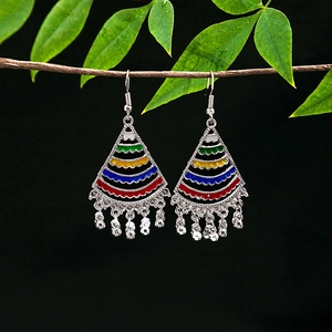 Detailed macro view of bohemian silver fan earrings with colorful enamel and bead tassels