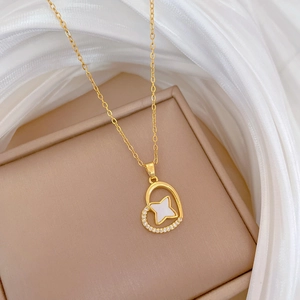 Detail of gold heart pendant with sparkling crystals and a mother of pearl star inlay