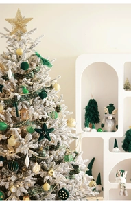 Close-up of deep green flocked ornaments and gold tree topper for luxury Christmas decor