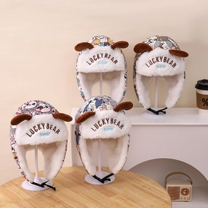 Détail de bonnets trappeur d'hiver avec imprimés cartoon, doublure polaire et protège-oreilles