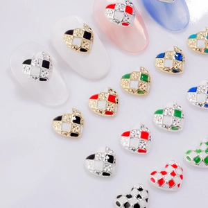 Macro view of checkered heart nail charms with rhinestone accents and enamel finish