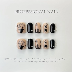 Detail view of handmade cat-eye press-on nails with forest elk and pine tree patterns