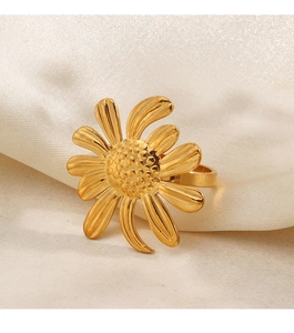 Vue détaillée d'une bague tournesol dorée sur un élégant fond en soie blanc cassé