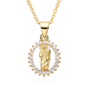 Macro detail of gold Saint Jude pendant with cubic zirconia and reflective surface